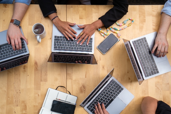 hands on laptops in an office setting