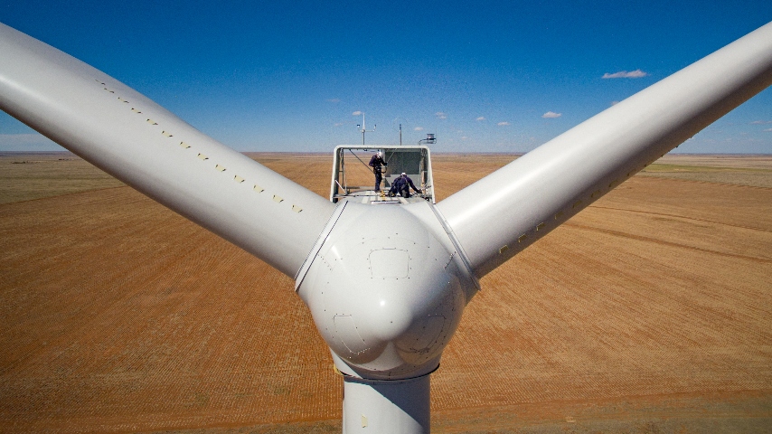 Technicians atop a wind turbine