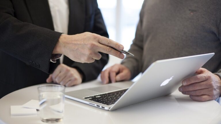 business consultants pointing at a computer screen